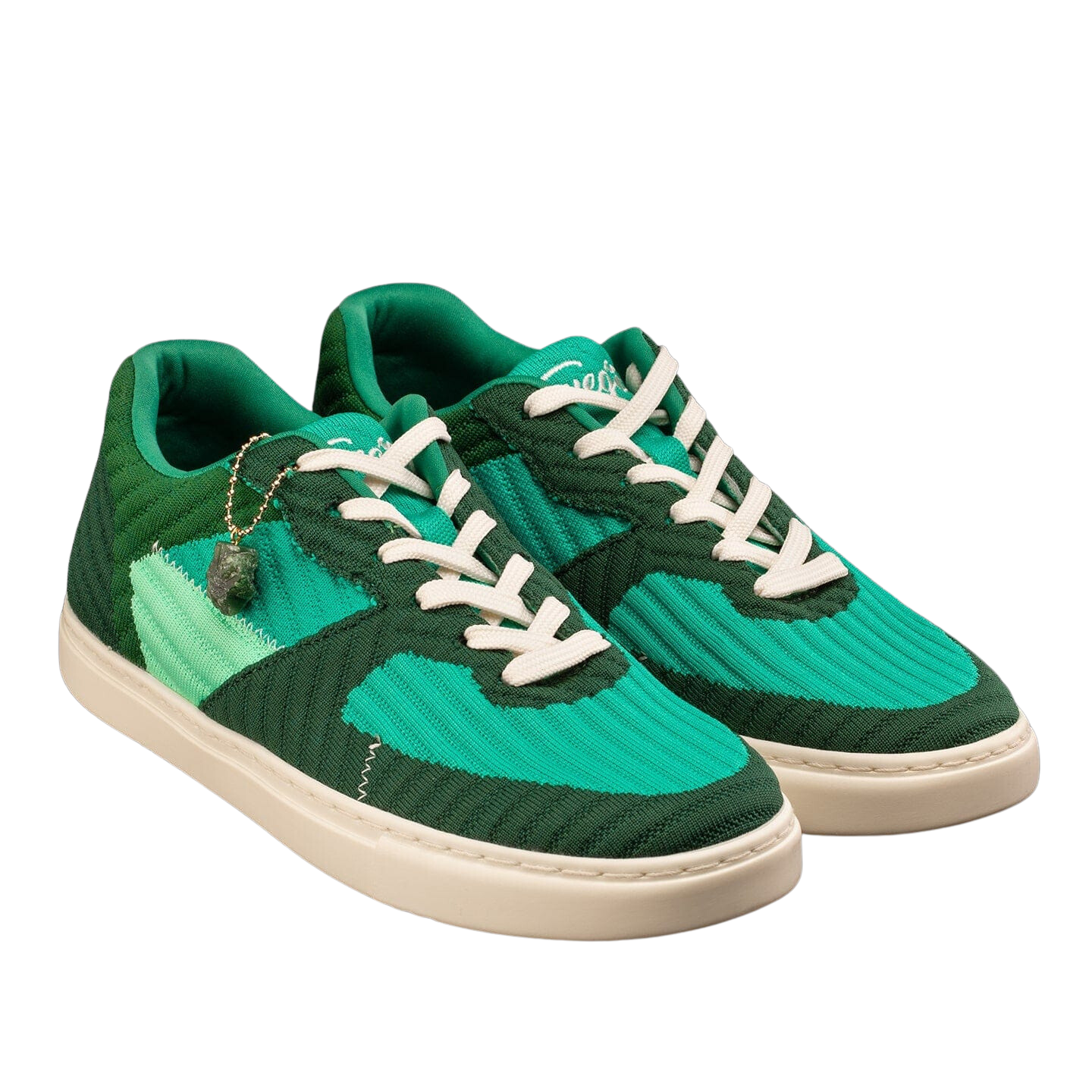 Fuego Jade Dance Sneakers in Grün von Fuego Dance Shoes haben weiße Sohlen, Schnürsenkel und einen baumelnden Anhänger.